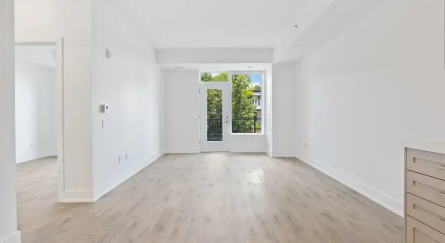 Salón luminoso con suelo de madera clara y puerta acristalada que da a un balcón. Ideal para vender piso heredado antes de 5 años.