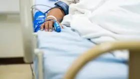 Paciente en cama de hospital con oxímetro en el dedo, indicando la necesidad de permiso por enfermedad.