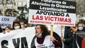 Manifestantes protestan contra la ocupación de vivienda habitual. Una mujer grita, portando un cartel que apoya a las víctimas de #Leyantiocupas.
