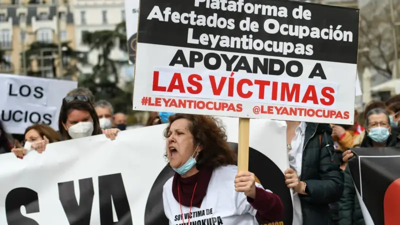 Manifestantes protestan contra la ocupación de vivienda habitual. Una mujer grita, portando un cartel que apoya a las víctimas de #Leyantiocupas.